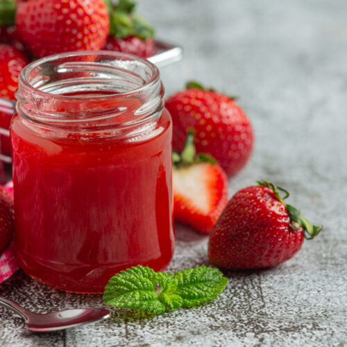 Strawberry jam on old dark background